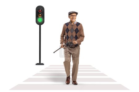 Photo for Happy elderly man walking at a pedestrian crossing and holding a cane isolated on white background - Royalty Free Image
