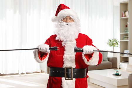 Téléchargez les photos : Père Noël débrancher les câbles à l'intérieur d'un appartement - en image libre de droit
