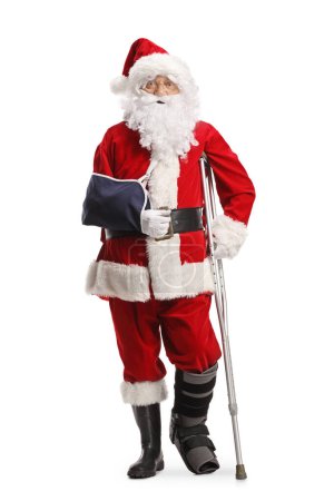Foto de Santa Claus con un soporte para los pies y una honda para los brazos apoyada en una muleta aislada sobre fondo blanco - Imagen libre de derechos