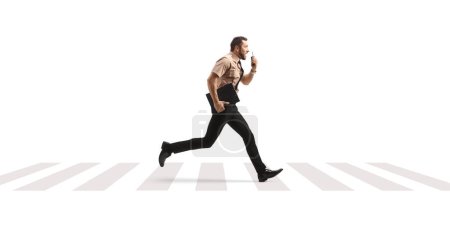 Photo for Full length profile shot of a security guard running at a pedestrian crossing and using a walkie talkie isolated on white background - Royalty Free Image