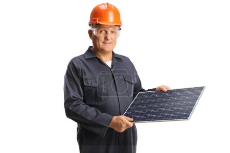 Foto de Trabajador de fábrica en uniforme con casco y gafas y sosteniendo un panel solar aislado sobre fondo blanco - Imagen libre de derechos