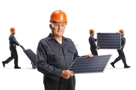 Foto de Fabricación de paneles solares, trabajadores portadores de fotovoltaica aislados sobre fondo blanco - Imagen libre de derechos