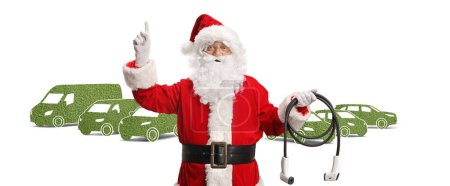 Photo for Santa claus in front of green vehicles holding a charger and pointing up isolated on white background - Royalty Free Image