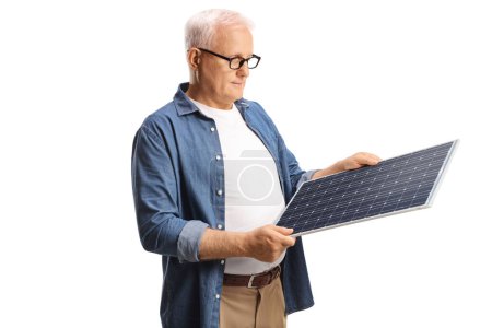 Foto de Hombre maduro causal mirando un panel solar aislado sobre fondo blanco - Imagen libre de derechos