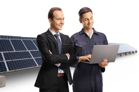 Foto de Empresario y técnico mirando una computadora portátil frente a la fotovoltaica aislada sobre fondo blanco - Imagen libre de derechos