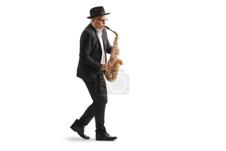 Téléchargez les photos : Plan de profil complet d'un musicien masculin mature jouant un saxophone isolé sur fond blanc - en image libre de droit