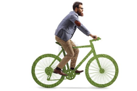 Téléchargez les photos : Homme barbu chevauchant un vélo en herbe isolé sur fond blanc - en image libre de droit