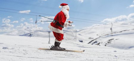 Foto de Perfil de longitud completa de Santa Claus esquiando en una montaña - Imagen libre de derechos