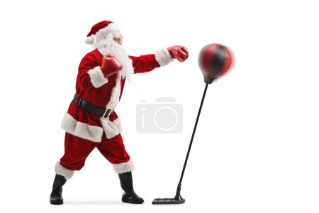 Photo for Full length profile shot of santa claus training box with a punching stand isolated on white background - Royalty Free Image