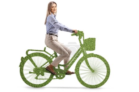 Téléchargez les photos : Jeune femme en vêtements formels chevauchant un éco vélo vert isolé sur fond blanc - en image libre de droit