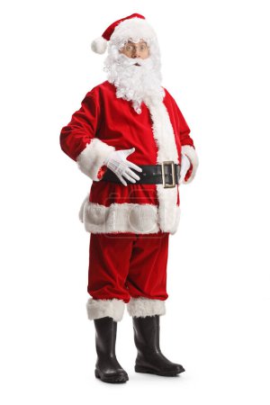 Téléchargez les photos : Portrait complet de jeune père Noël debout avec les mains sur le ventre et l'air surpris isolé sur fond blanc - en image libre de droit