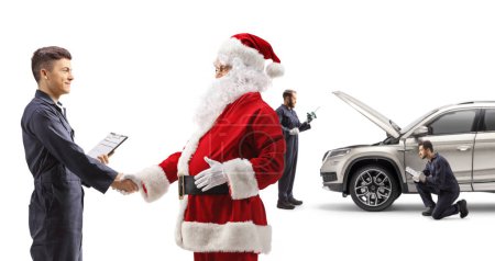 Photo for Santa claus and auto repair worker shaking hands in front of a SUV isolated on white background - Royalty Free Image