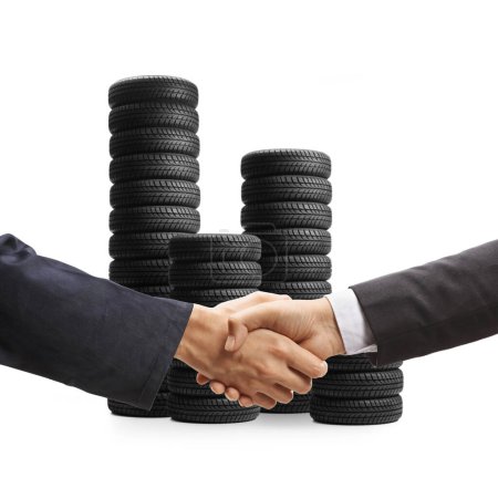 Photo for Auto mechanic and a businessman shaking hands in front of car tires isolated on white background - Royalty Free Image