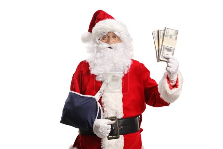 Téléchargez les photos : Père Noël avec une blessure au bras portant une fronde et tenant de l'argent isolé sur fond blanc - en image libre de droit
