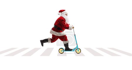 Photo for Full length profile shot of Santa Claus riding a push scooter at a pedestrian crossing isolated on white background - Royalty Free Image