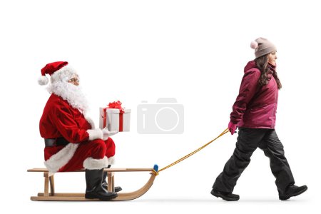 Téléchargez les photos : Fille tirant un tour avec le Père Noël assis et tenant un cadeau isolé sur fond blanc - en image libre de droit