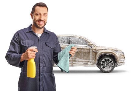 Photo for Worker holding a wiping cloth and a cleaning spray in front of a SUV with soap foam isolated on white background - Royalty Free Image
