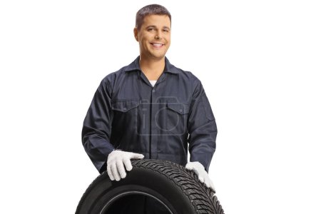 Photo for Young car mechanic behind a car tire isolated on white background - Royalty Free Image