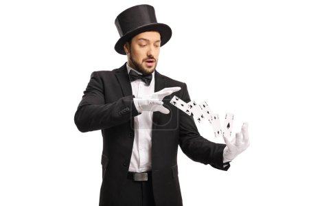 Photo for Magician wearing white gloves and performing a trick with flying cards isolated on white background - Royalty Free Image