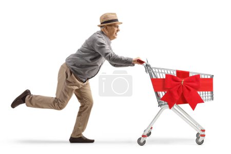 Téléchargez les photos : Prise de vue pleine longueur d'un vieux gentleman courant avec chariot vide attaché avec ruban rouge arc isolé sur fond blanc - en image libre de droit