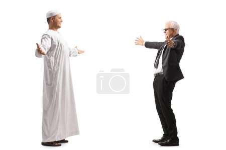 Téléchargez les photos : Un homme musulman rencontre et salue un homme d'affaires mature isolé sur fond blanc - en image libre de droit