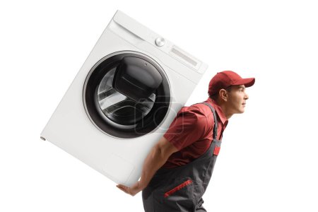 Téléchargez les photos : Profil d'un travailleur en uniforme portant une machine à laver sur le dos isolé sur fond blanc - en image libre de droit
