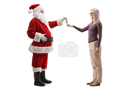 Téléchargez les photos : Photo de profil pleine longueur de Père Noël donnant des clés de voiture à une jeune femme isolée sur fond blanc - en image libre de droit