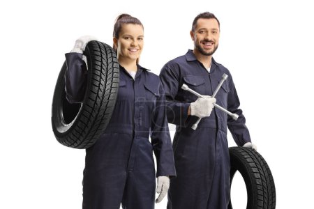 Photo for Male and female car mechanic workers holding lug wrench tool and a car tire isolated on white background - Royalty Free Image