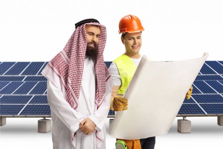 Foto de Obrero de la construcción mostrando plan de planta fotovoltaica a un árabe saudí aislado sobre fondo blanco - Imagen libre de derechos