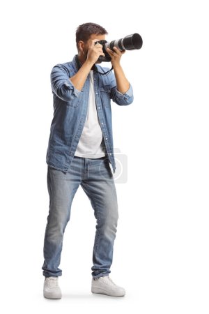 Téléchargez les photos : Plan complet d'un homme prenant une photo avec un appareil photo professionnel isolé sur fond blanc - en image libre de droit