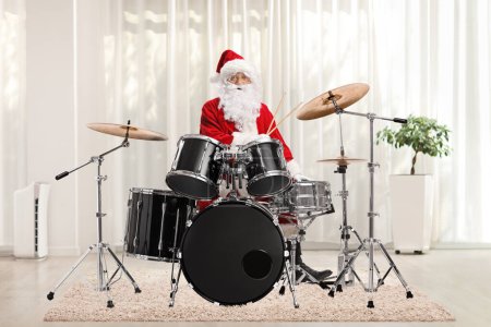 Photo for Santa claus on percussion, playing drums in a room - Royalty Free Image
