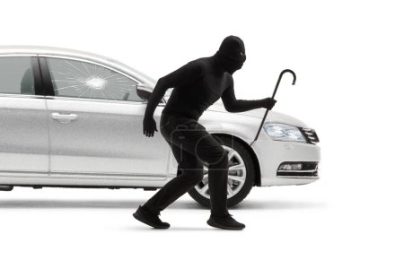 Photo for Burglar with balaclava and a crowbar breaking a car window isolated on white background - Royalty Free Image