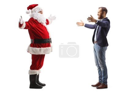 Téléchargez les photos : Photo de profil pleine longueur d'un homme heureux rencontrant Père Noël claus isolé sur fond blanc - en image libre de droit