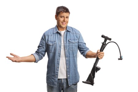 Photo for Confused young man holding a manual tire pump isolated on white background - Royalty Free Image