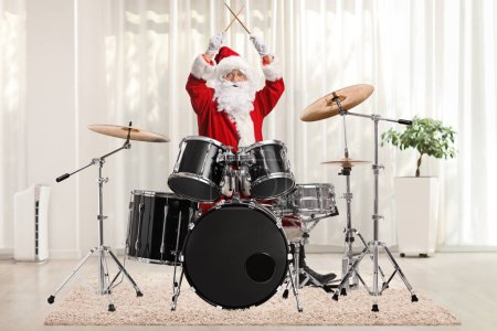 Téléchargez les photos : Père Noël jouer de la batterie à la maison dans une pièce avec un rideau à l'arrière - en image libre de droit