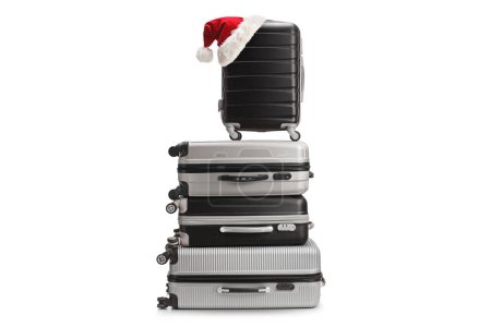 Téléchargez les photos : Pile de valises avec un santa claus chapeau sur le dessus isolé sur fond blanc - en image libre de droit