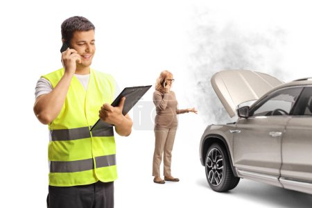 Téléchargez les photos : Travailleur de l'aide routière parler à une femme avec une panne de voiture sur le téléphone isolé sur fond blanc - en image libre de droit