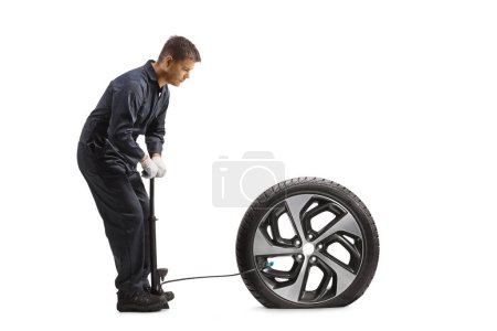 Téléchargez les photos : Mécanicien automobile utilisant une pompe manuelle pour un pneu crevé isolé sur fond blanc - en image libre de droit