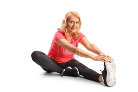 Photo for Mature woman stretching leg on the floor and smiling isolated on white background - Royalty Free Image