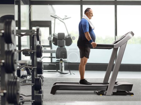Photo for Full length profile shot of a mature man standing on a treadmill at the gym - Royalty Free Image