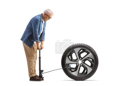 Téléchargez les photos : Homme mûr utilisant une pompe manuelle pour un pneu de voiture d'hiver isolé sur fond blanc - en image libre de droit