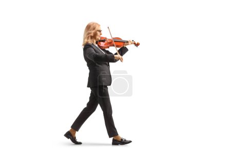Photo for Full length profile shot of a woman walking and playing a violin isolated on white background - Royalty Free Image