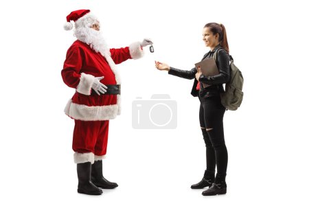 Téléchargez les photos : Photo de profil pleine longueur de Père Noël donnant des clés de voiture à une étudiante isolée sur fond blanc - en image libre de droit