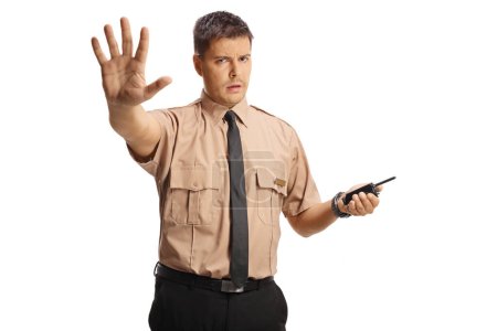 Téléchargez les photos : Agent de sécurité en colère tenant un talkie-walkie et gestruing stop isolé sur fond blanc - en image libre de droit