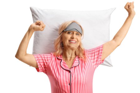 Téléchargez les photos : Heureuse femme mûre en pyjama s'étendant sur un oreiller isolé sur fond blanc - en image libre de droit