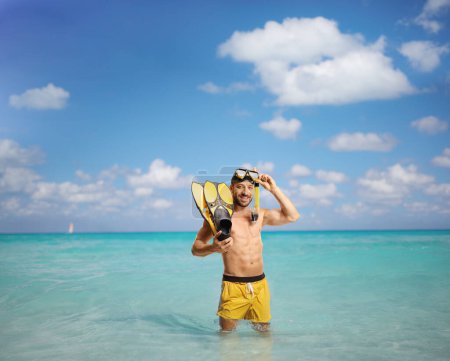 Photo for Man with snorkeling fins and mask standing in the blue Caribbean Sea - Royalty Free Image