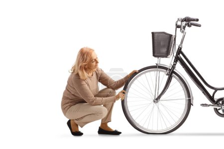 Photo for Woman kneeling and checking bicycle tire isolated on white backgroun - Royalty Free Image