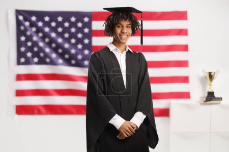 Téléchargez les photos : Étudiant diplômé afro-américain devant un drapeau américain - en image libre de droit
