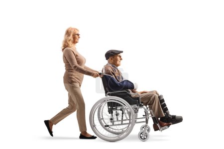 Photo for Mature woman pushing an elderly injured man in a wheelchair isolated on white background - Royalty Free Image