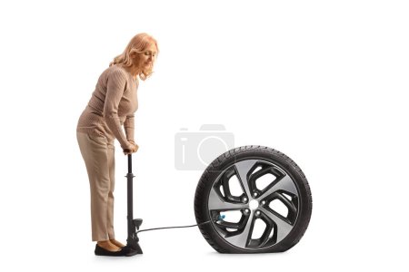 Téléchargez les photos : Femme utilisant une pompe manuelle pour un pneu de voiture à plat isolé sur fond blanc - en image libre de droit